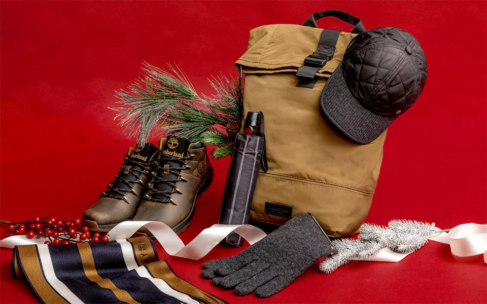 Still-Life von einem Rucksack, Wanderstiefeln, Regenschirm, Mütze, Schal und Handschuhen mit weihnachtlicher Dekoration