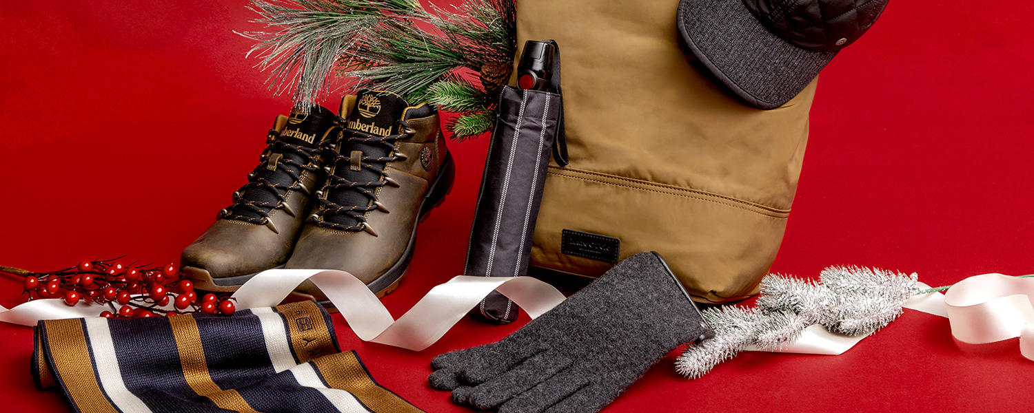 Still-Life von einem Rucksack, Wanderstiefeln, Regenschirm, Mütze, Schal und Handschuhen mit weihnachtlicher Dekoration