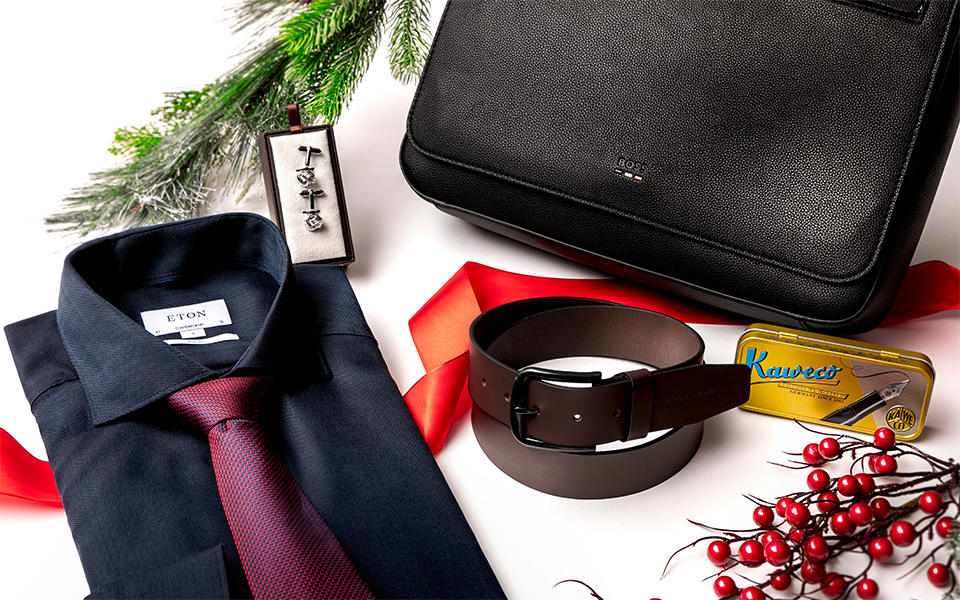 Still-Life von einem Hemd mit Krawatte, einem Leder-Gürtel, Stifte-Etui und einer Laptoptasche mit weihnachtlicher Dekoration