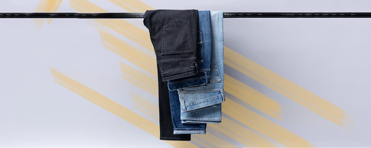 Drei Jeans aufeinander gelegt auf einer Stange