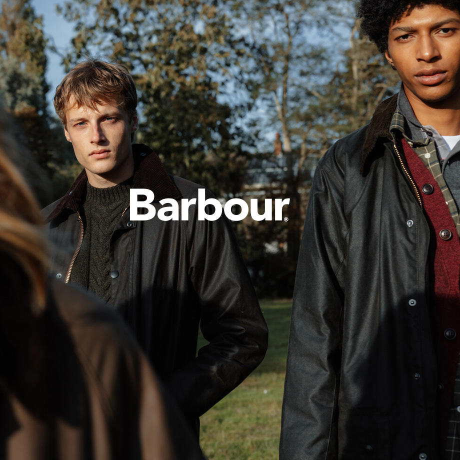 Zwei junge Männer tragen Barbour Wachsjacken. Mittiges Logo: "Barbour"