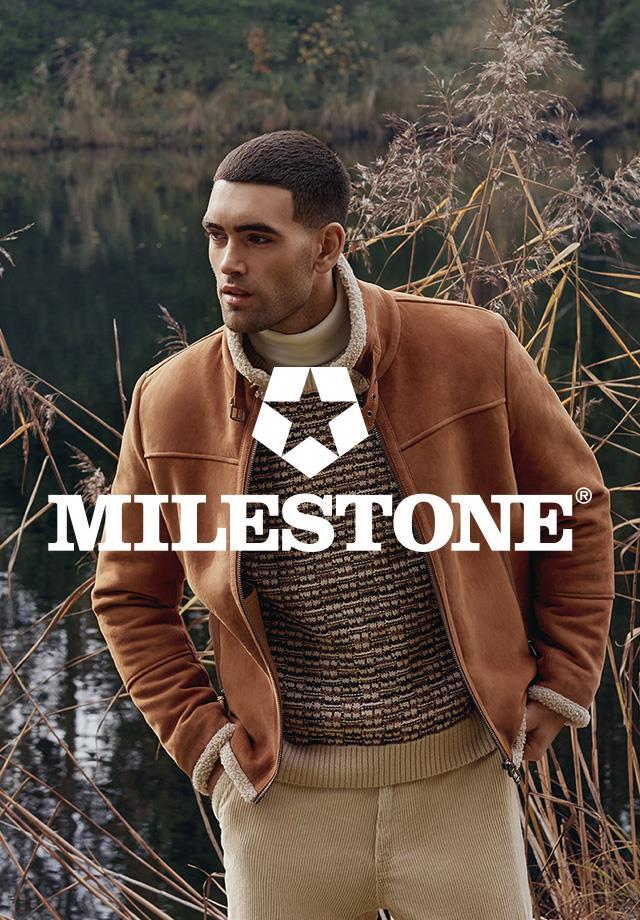 Das Bild zeigt einen Mann in brauner Wildlederjacke mit Teddyfutter von Milestone, dazu trägt er einen braun-beige gemusterten Pullover und beige Hose.