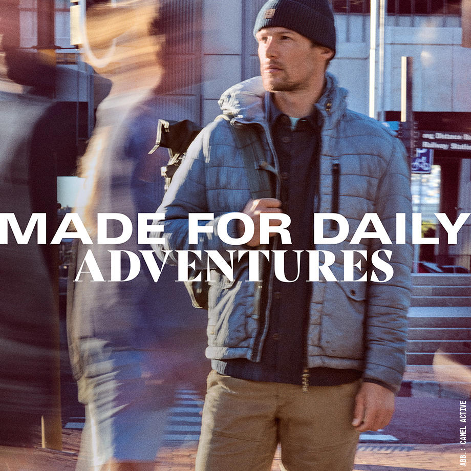 Mann steht in Outdoorkleidung in einer Stadt. Menschen laufen an ihm vorbei, mit Bewegungsunschärfe, Schriftzug: Made for daily Adventures