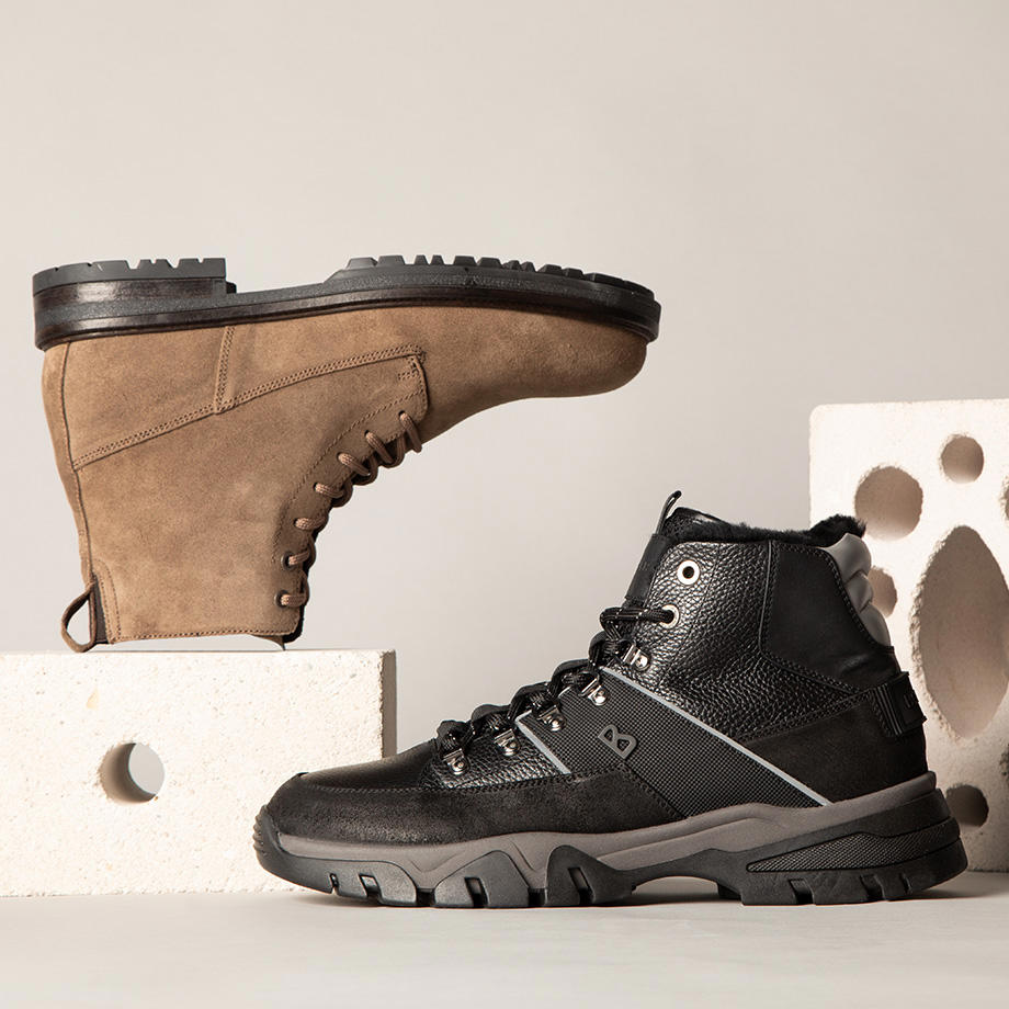 Ein Stillleben von zwei Boots mit weißen Betonsteinen vor grauem Hintergrund
