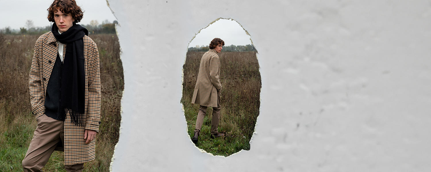 Eine Collage aus zwei Bildern von einem männlichen Model auf einem abgeernteten Feld. Er trägt einen karierten Mantel, eine braune Hose und einen dunkelblauen Schal.