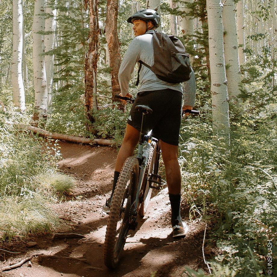 Ein Mann fährt mit seinem Fahrrad durch den Wald.