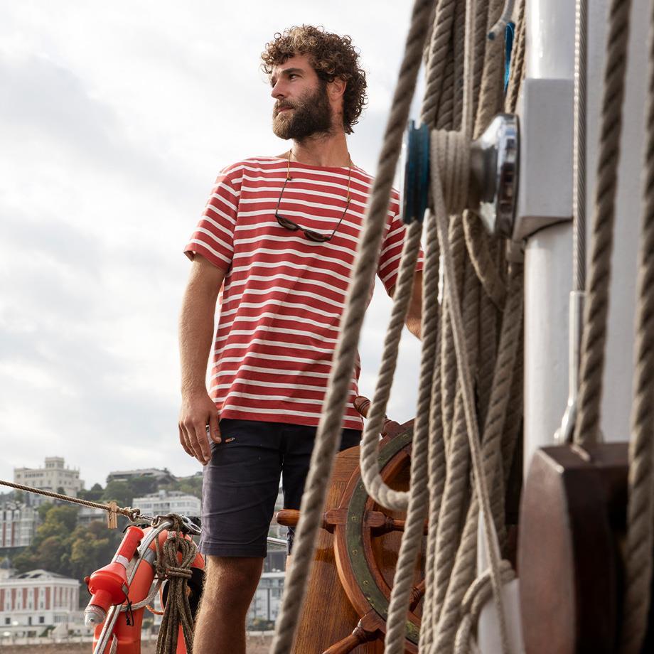 Mann mit maritimer Kleidung mit rot-weißem T-Shirt & blaue Shorts