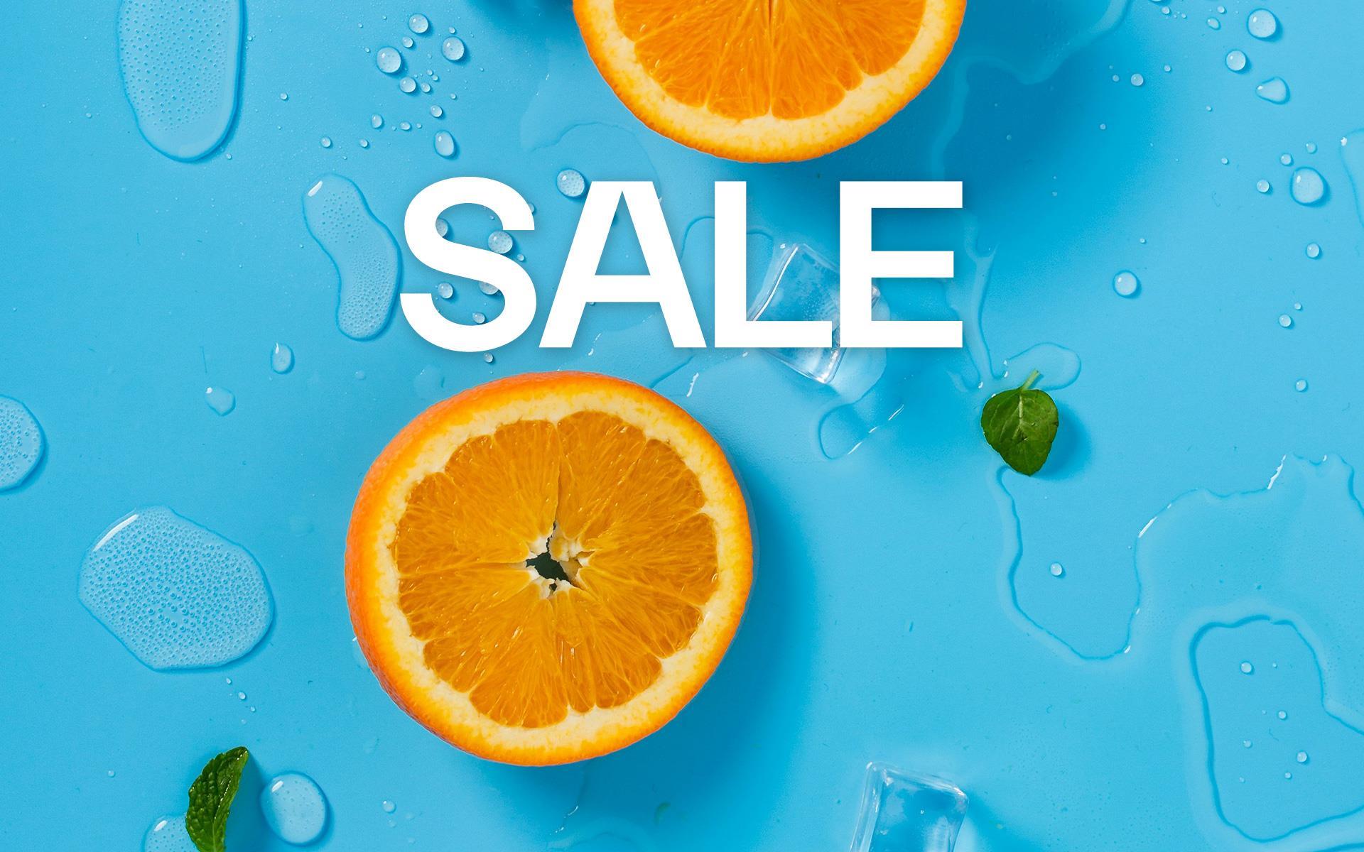 Das Bild zeigt das Thema Sale mit einem blauen Hintergrund, dekoriert mit Orangenscheiben und Wassertropfen. 