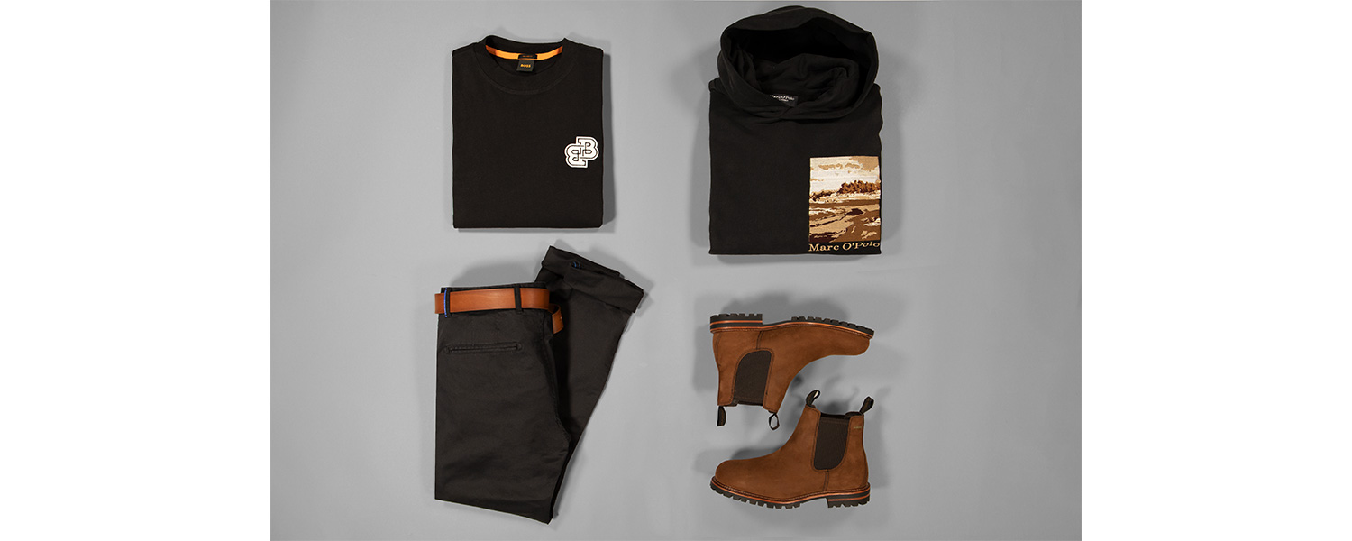 Graue Hose mit braunen Chelsea Booss, schwarzem Hoodie und schwarzem Shirt kombiniert