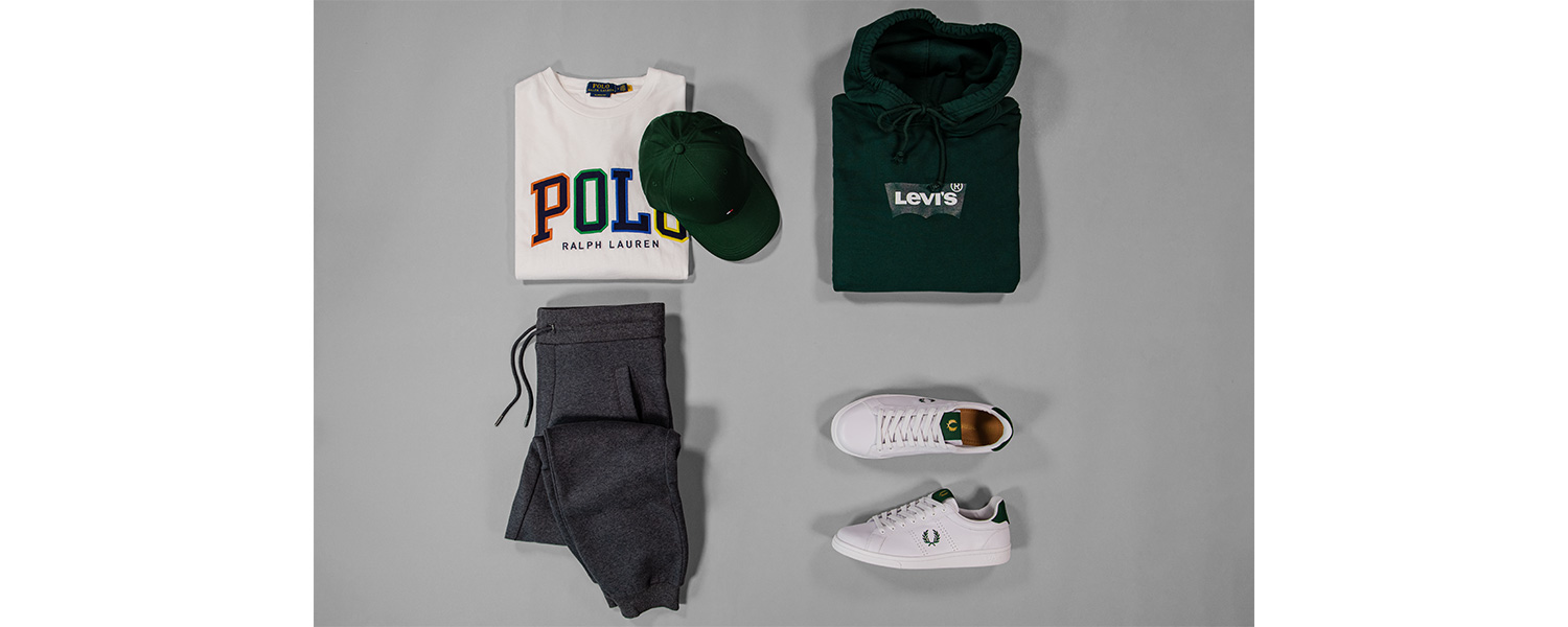 Graue Hose mit Logo-Shirt, grünem Hoodie, grüner Cap und weiß-grünen Sneakers kombiniert