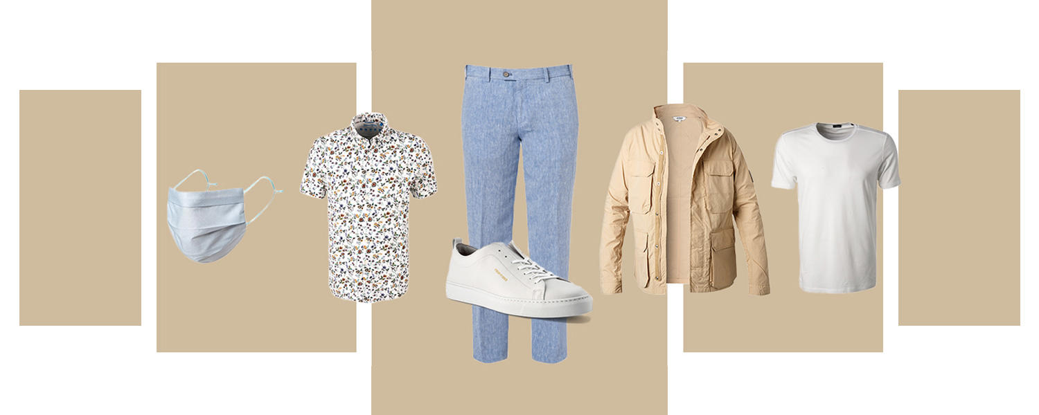 Ein Outfit bestehend aus Mundschutzmaske, Blumenhemd, hellblauer Hose, weißen Sneakers, beiger Jacke und weißem T-Shirt.