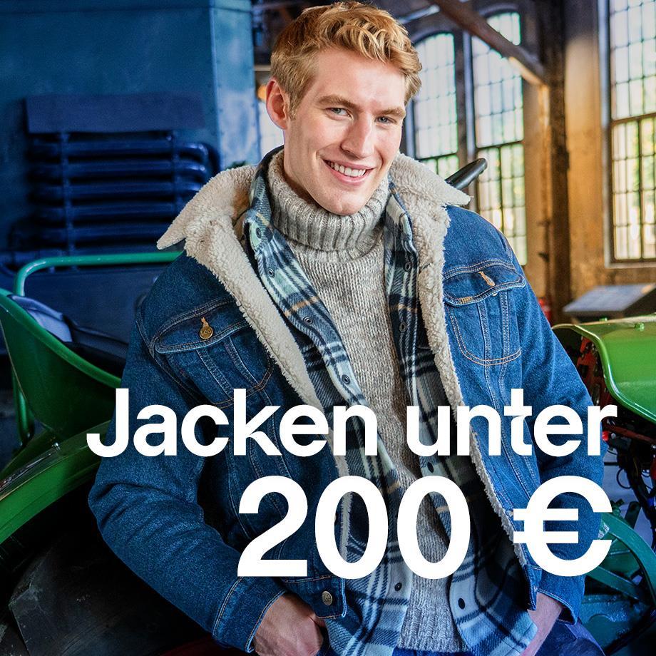 Das Bild zeigt einen Mann, der eine blaue Jeansjacke mit Teddyfell Futter trägt; darunter ein kariertes Hemd & einen grauen Rollkragenpullover.