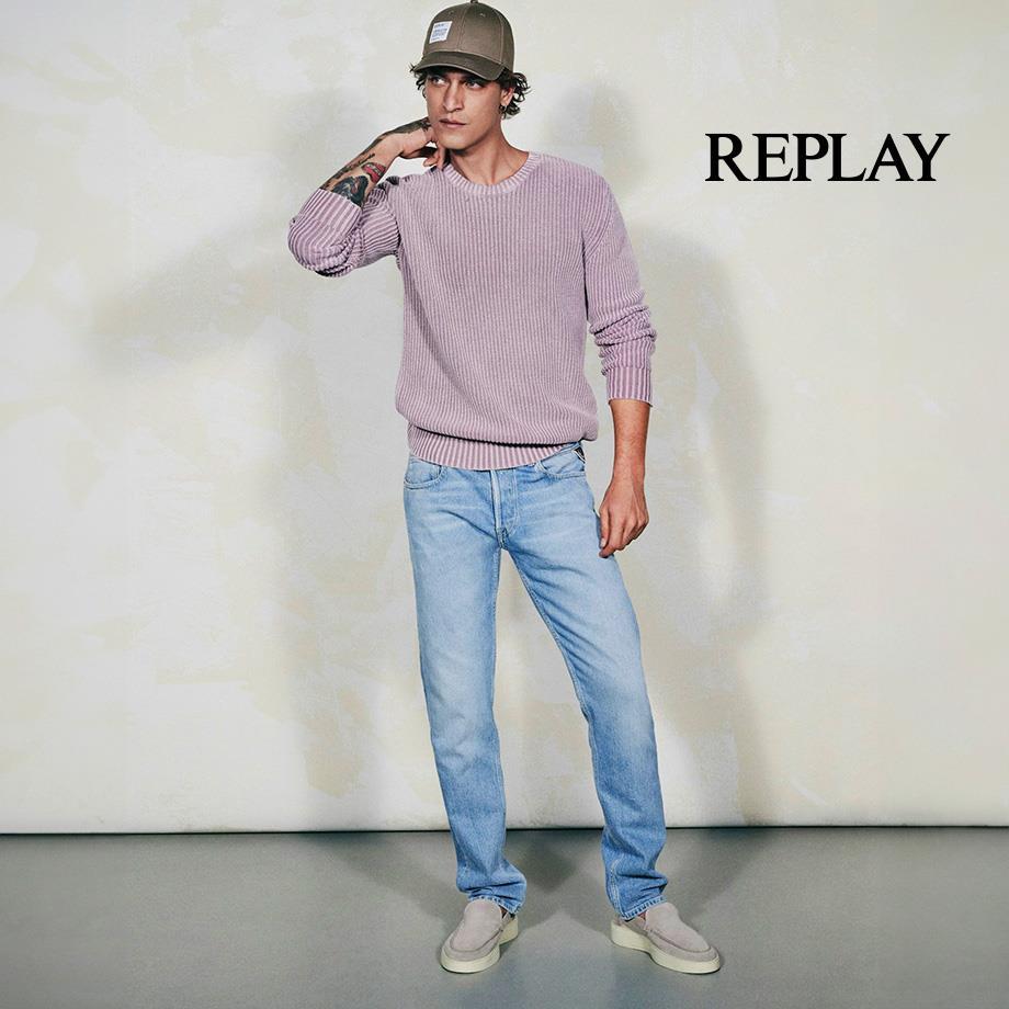  Ein Mann trägt hellblaue Jeans von Replay und einen fliederfarbenen Pullover