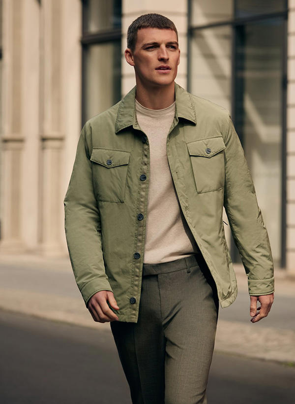 Ein Mann trägt ein olivgrünes Overshirt