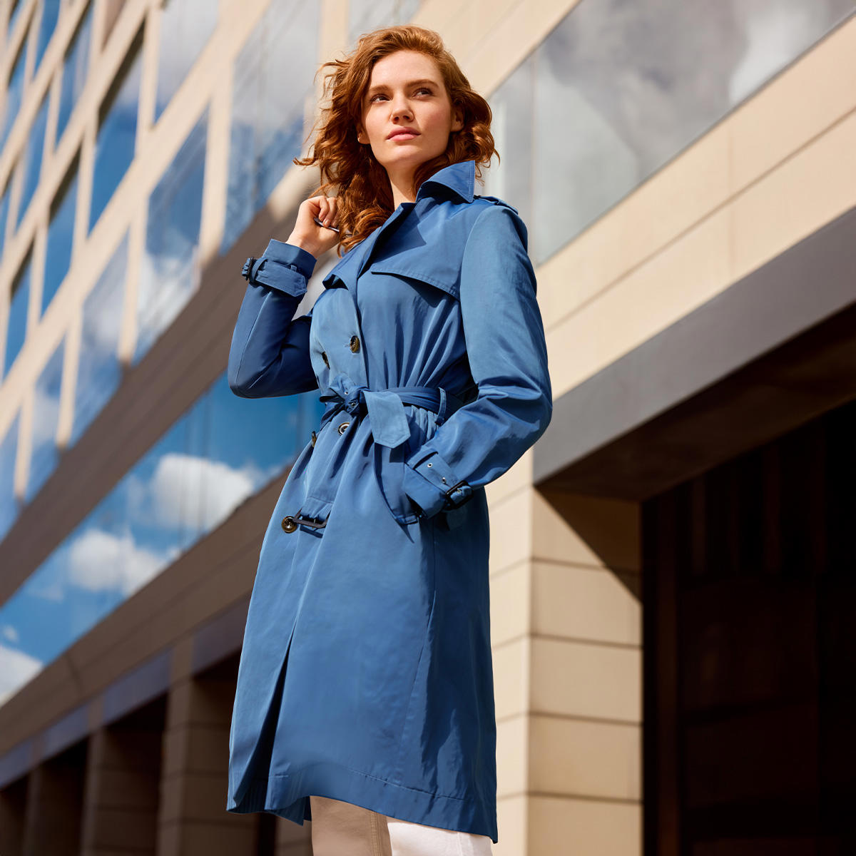 Eine Frau in blauem Trenchcoat
