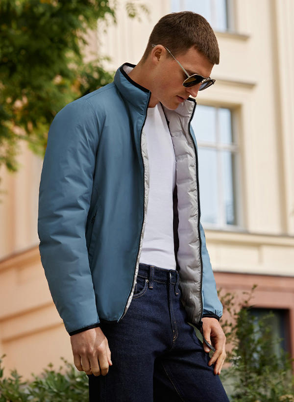 Ein Mann in einer blau-weißen Wendejacke