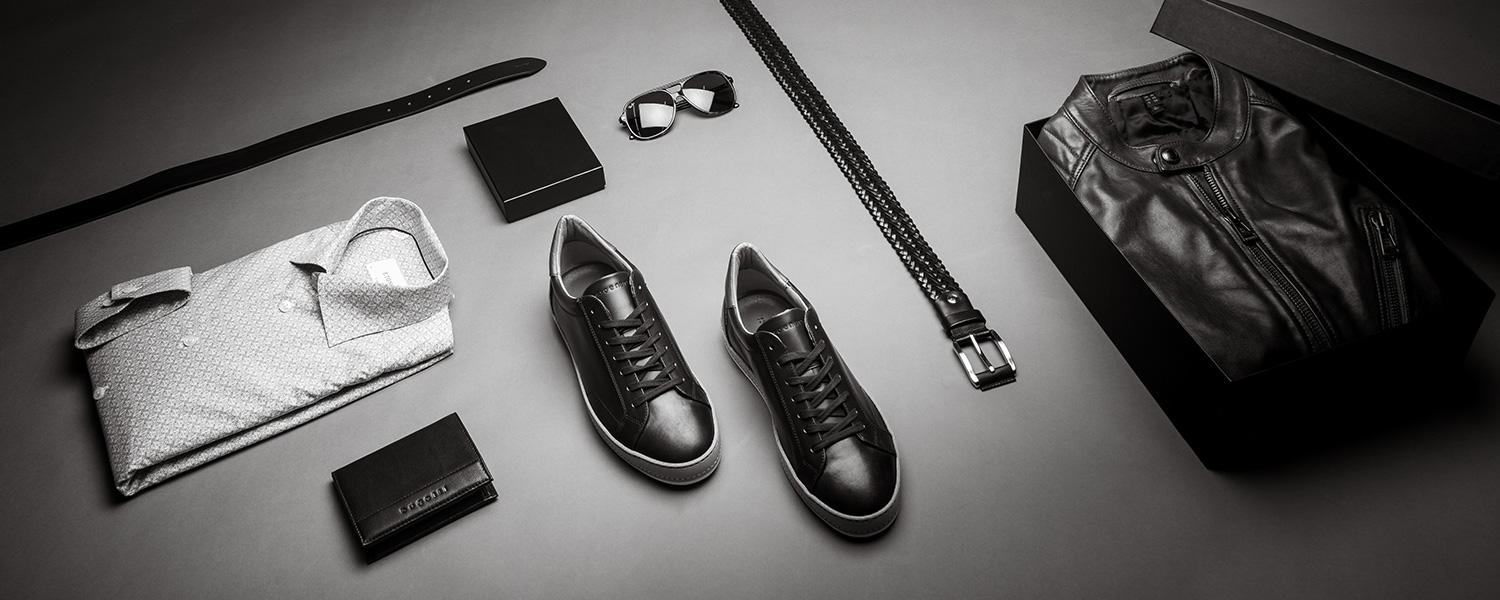 Schwarze Lederjacke, Sneakers und Accessoires – moderner Herren-Look mit Gürtel, Hemd und Sonnenbrille im lässigen Style.