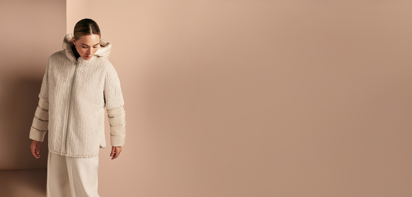 Eine Dame trägt eine Jacke aus Kunstfell mit Steppärmeln