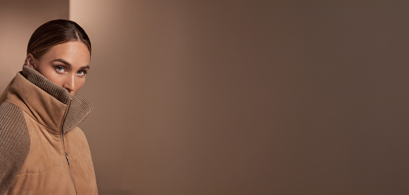 Eine Dame trägteine Jacke aus Veloursleder mit Strickelementen