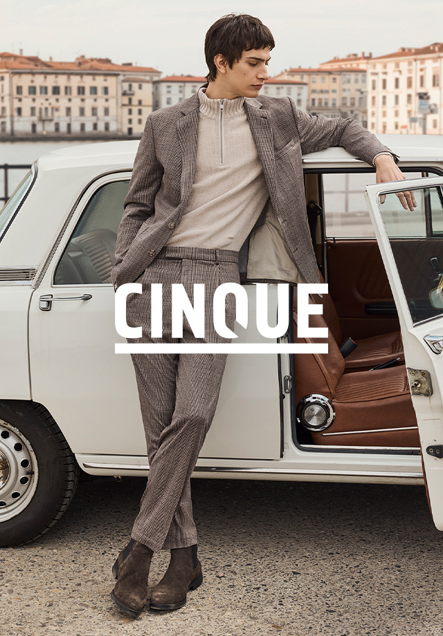 Check-Anzug in Braun mit passendem Zipper-Pullover, lässig an Auto gelehnt