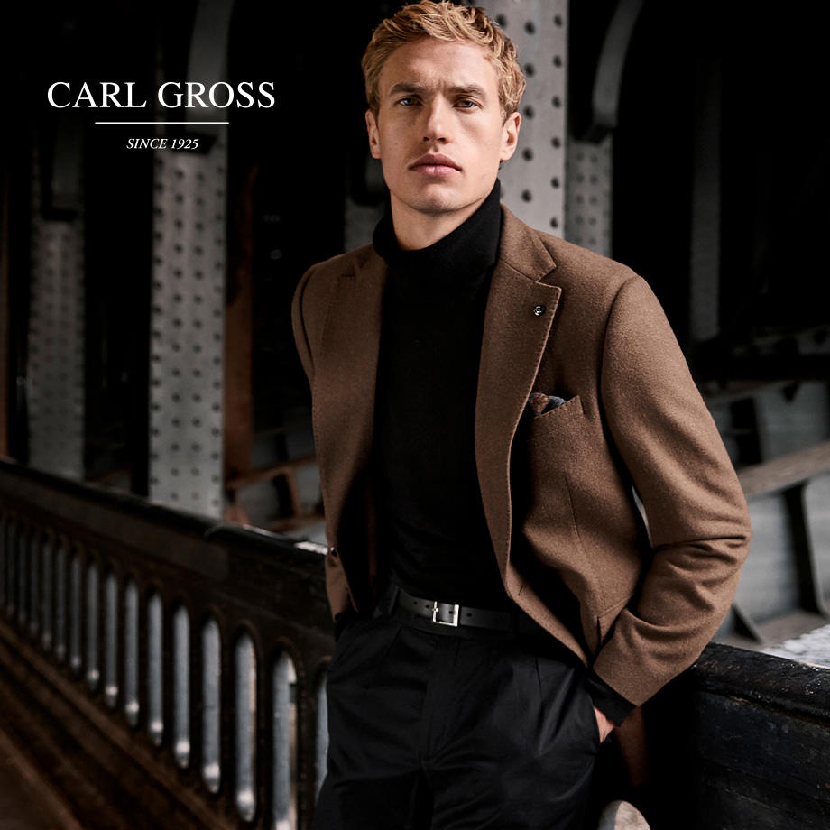 Herr in braunem Sakko und schwarzem Rollkragenpullover, klassisch-elegant gekleidet
