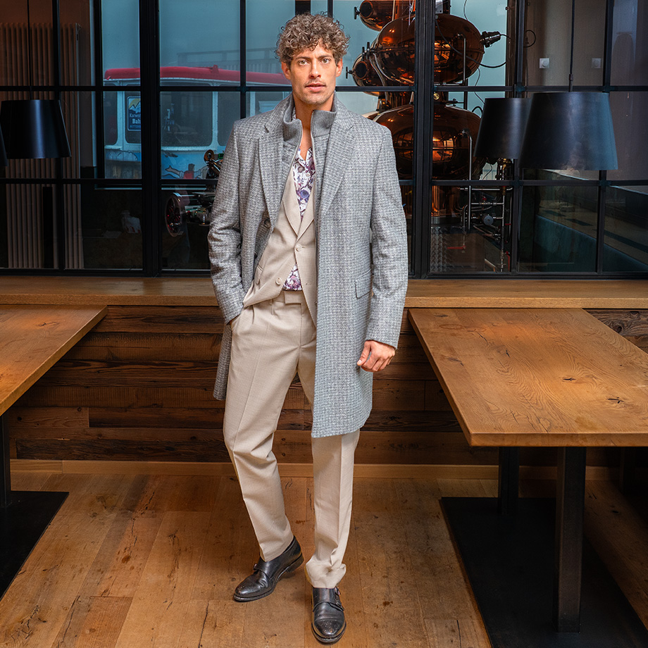 Hellgrauer Wollmantel über beigefarbenem Anzug, floralem Hemd, Freizeitlook im Restaurant