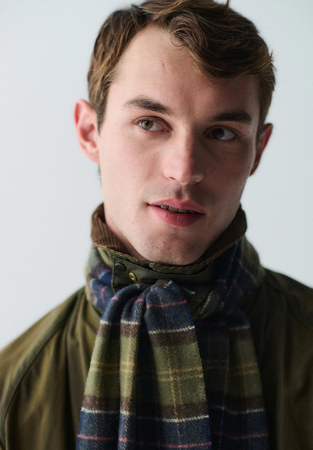 Mann mit kariertem Wollschal in Olivgrüner Jacke, elegant gebunden