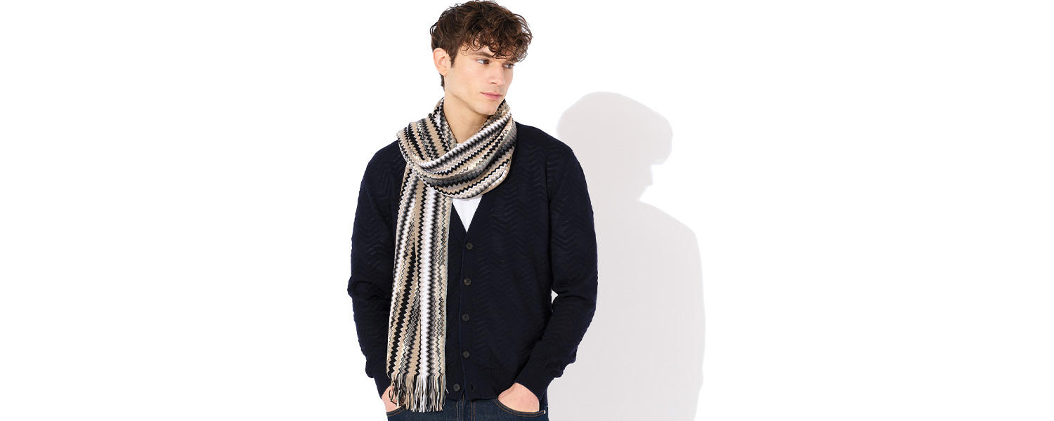 Mann in dunkelblauer Strickjacke mit gestreiftem Schal, aus Wolle, lässig präsentiert
