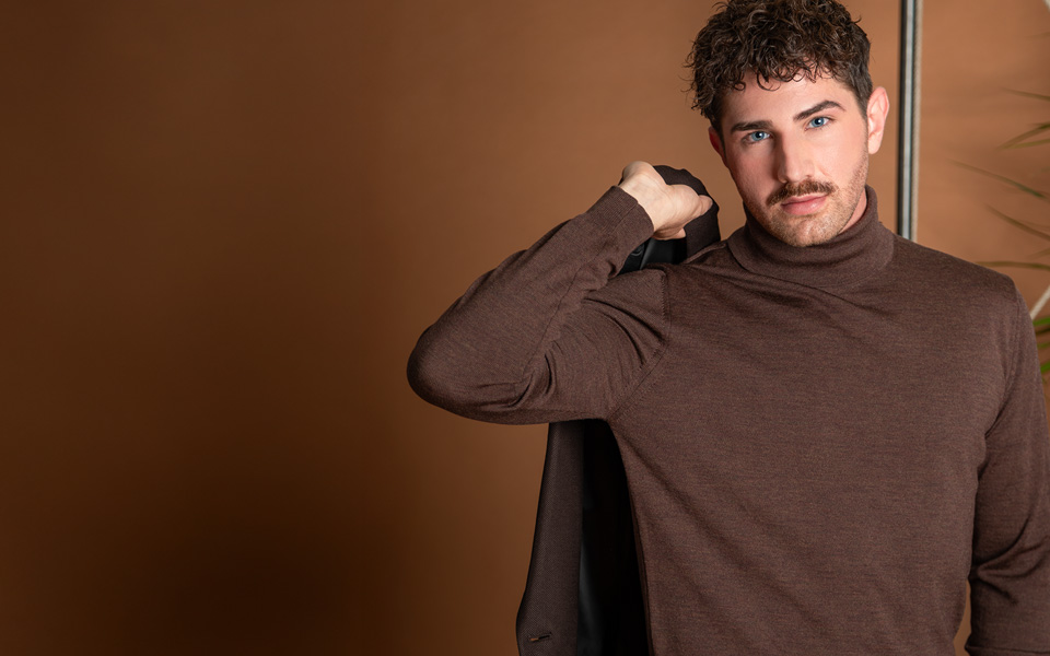 Brauner Rollkragenpullover aus Wolle, lässig über Schulter getragen