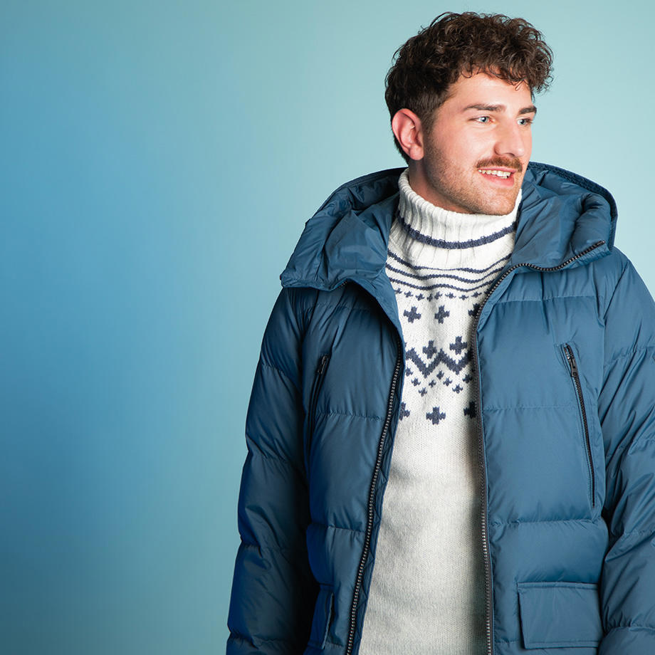 Blauer Daunen-Parka mit weißem Norwegerpullover darunter, lässig getragen