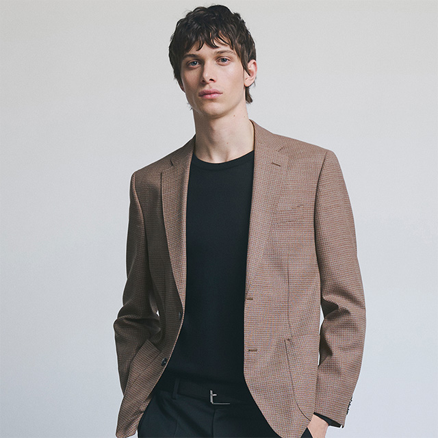 Herr im braunen Karo-Sakko über schwarzem T-Shirt, klassisch elegant