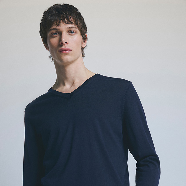 Mann in dunkelblauem V-Ausschnitt-Pullover, schlichtes Design