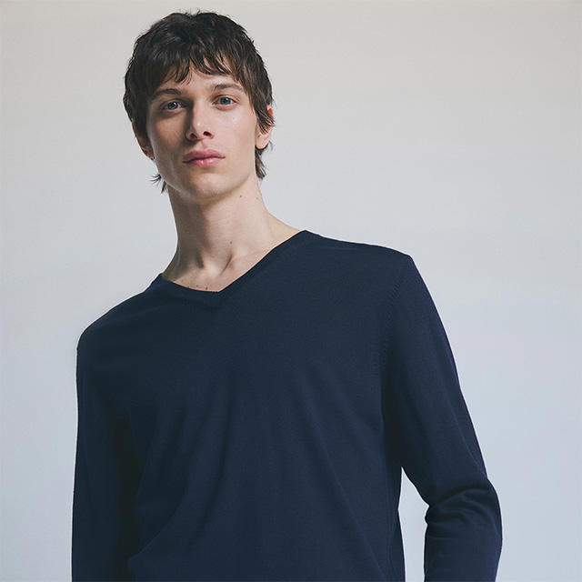 Mann in dunkelblauem V-Ausschnitt-Pullover, schlichtes Design