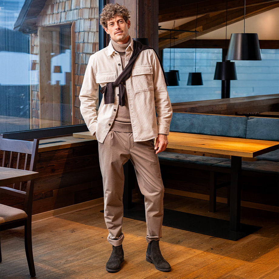 Mann in beiger Cordjacke mit Rollkragenpullover und Chinos, freizeitlich kombiniert