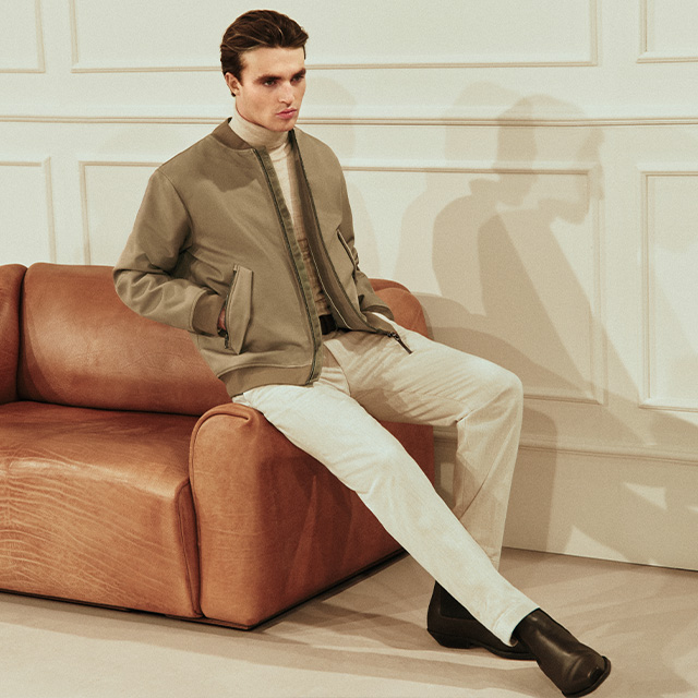 Hellbeige Bomberjacke mit Rollkragen und heller Stoffhose, entspannter Casual-Look.