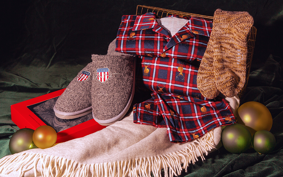 Karierte Herren-Pyjamahose in Rot-Blau mit grauen Hausschuhen und braunen Socken, winterlich arrangiert