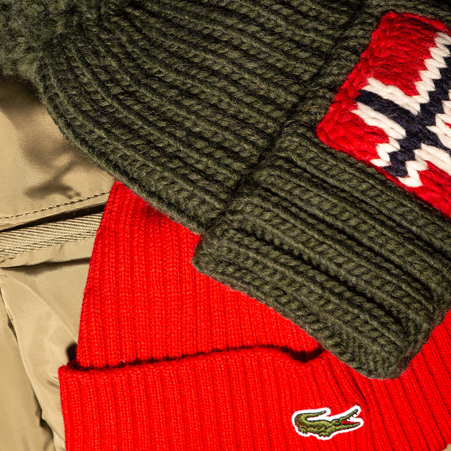 Grüne Strickmütze mit rotem Muster und beige Jacke