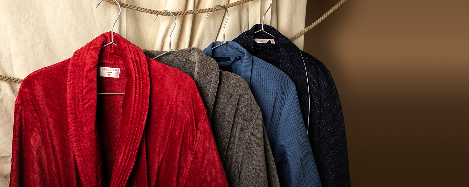 Verschiedene Herren-Bademäntel in Rot, Grau, Blau aus Baumwolle, auf Bügeln hängend