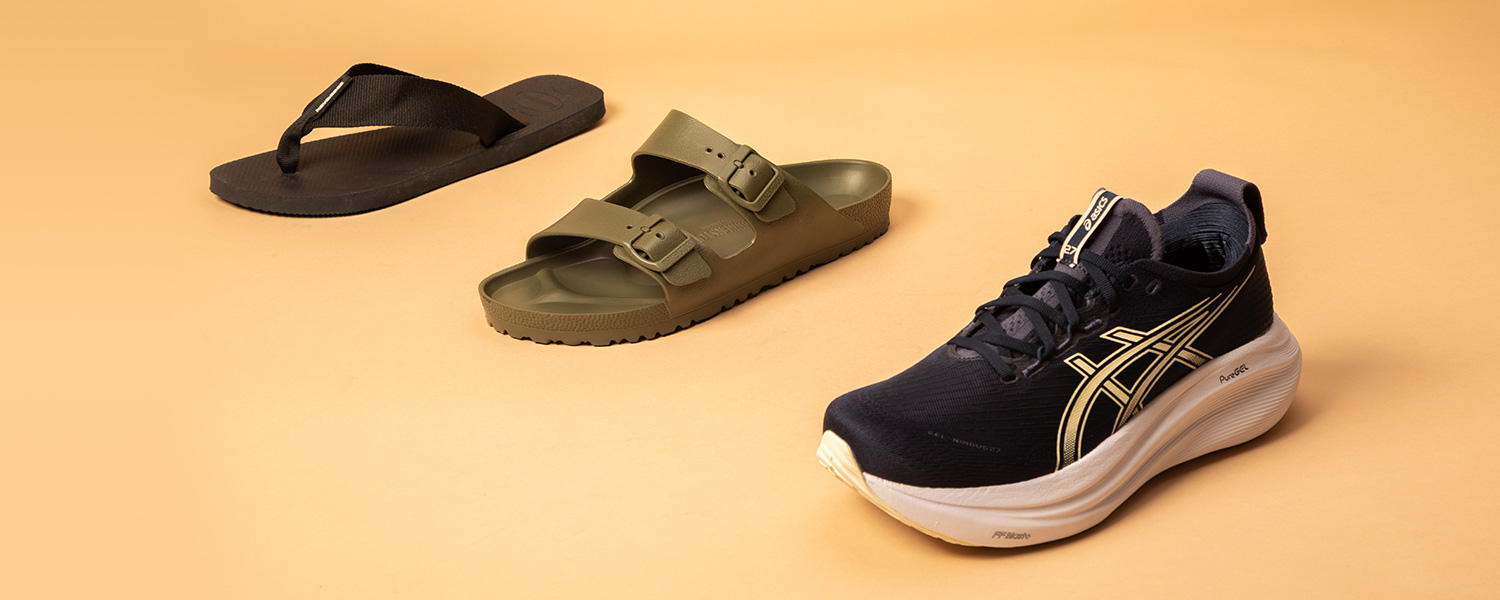Schwarze Zehensandale, olivgrüne Sandale und schwarz-goldener Laufschuh auf beigem Hintergrund.