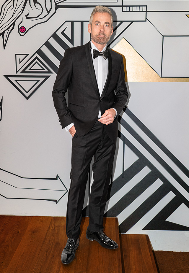 Eleganter schwarzer Anzug mit weißem Hemd und Fliege, formell getragen von Mann, hochwertige Herrenmode