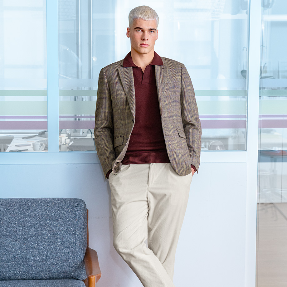 Elegantes Karomuster-Sakko in Braun mit bordeauxrotem Poloshirt und beigen Hosen, lässig im Büro getragen