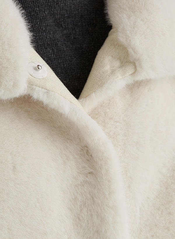 Beige Wollmantel mit Plüschstruktur, Kragenansicht, über dunklem Pullover getragen