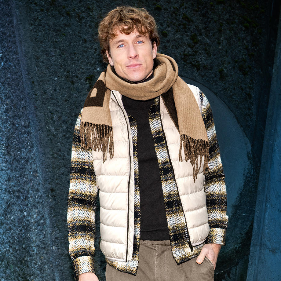 Mann in kariertem Wollhemd mit gestepptem Bodywarmer und Schal