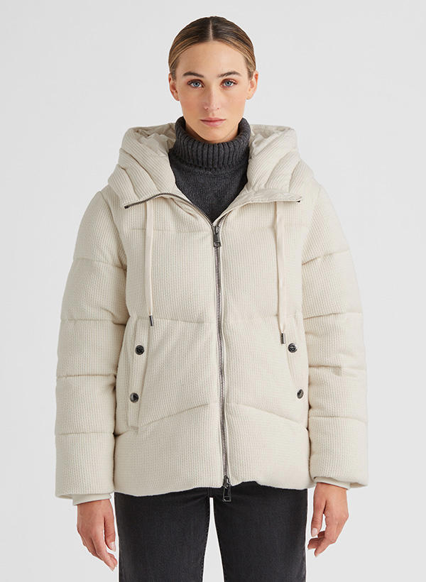 Cremefarbene Steppjacke mit Kapuze und Reißverschluss, kombiniert mit dunklem Rollkragen – moderner Casual-Winterlook.