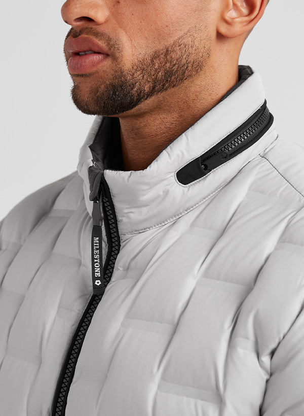 Hellgraue Steppjacke mit hohem Kragen und Reißverschluss, körpernah getragen