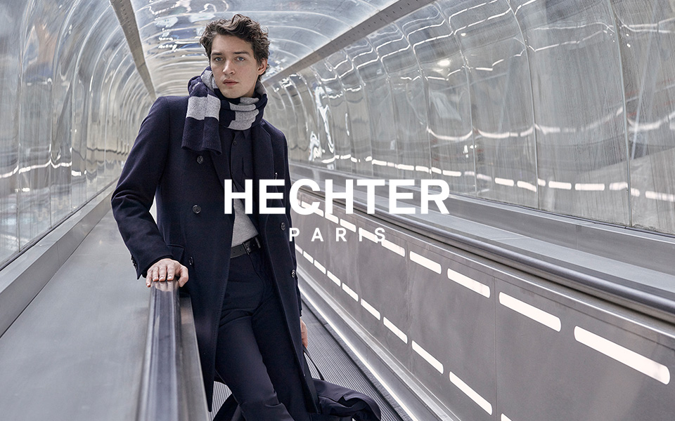 Hechter Paris: Mann im dunkelblauen Wollmantel mit gestreiftem Schal in modernem Tunnelgang