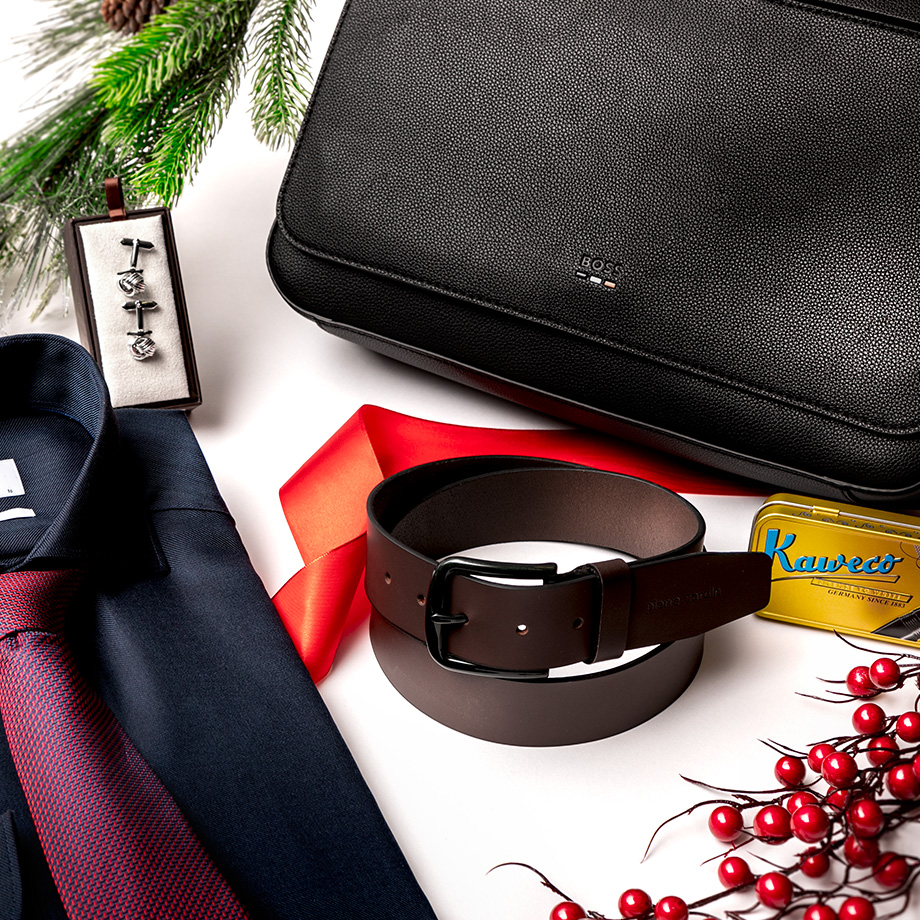 Dunkelblaues Business-Hemd mit roter Krawatte, brauner Ledergürtel und schwarze Ledertasche auf weißem Hintergrund