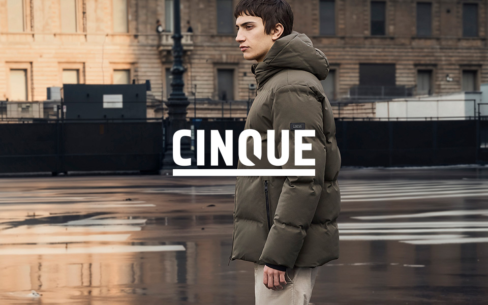 Cinque: Mann in olivgrüner Daunenjacke, urbaner Hintergrund, Kombination mit beigen Chinos