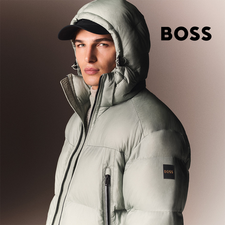 Hellgraue Daunenjacke mit Kapuze, getragen von Mann mit schwarzer Cap.