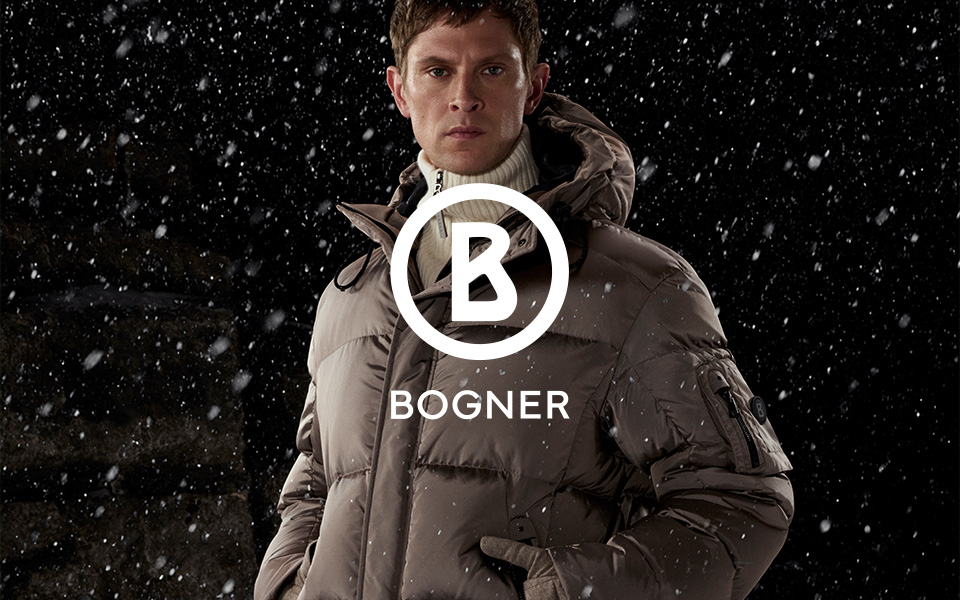 Mann in brauner Daunenjacke mit Kapuze im Schneefall